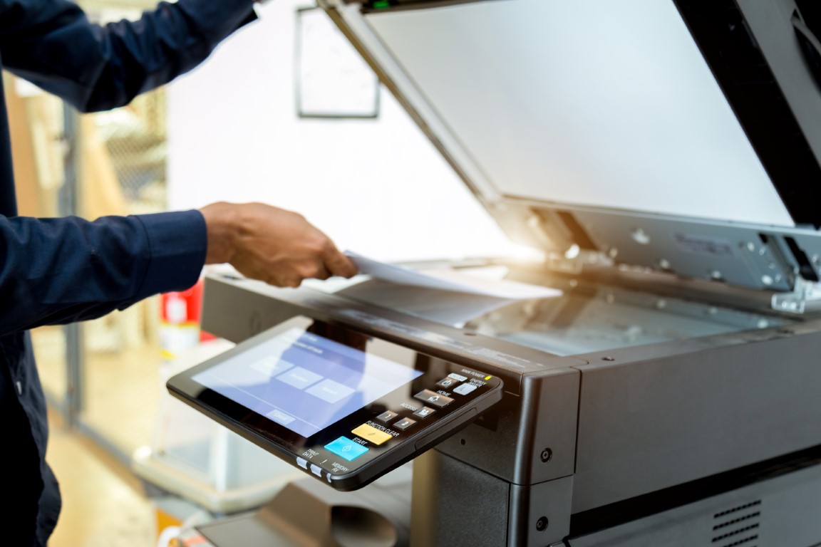 <p>Formpipe input management, a man putting a document in a scanner.</p>