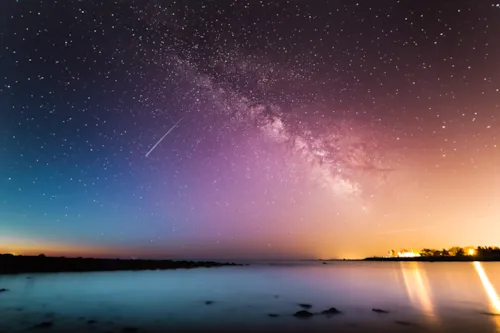 <p>A colourful night sky with a shooting star.</p>