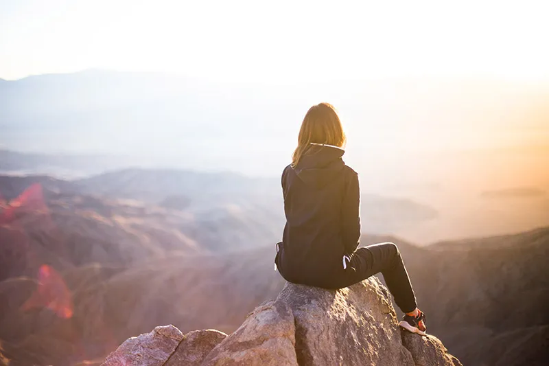 <p>A woman sitting on a mountain looking at the sunset over a mountain landscape a.k.a. Lasernet keeping a careful eye on what's happening.</p>