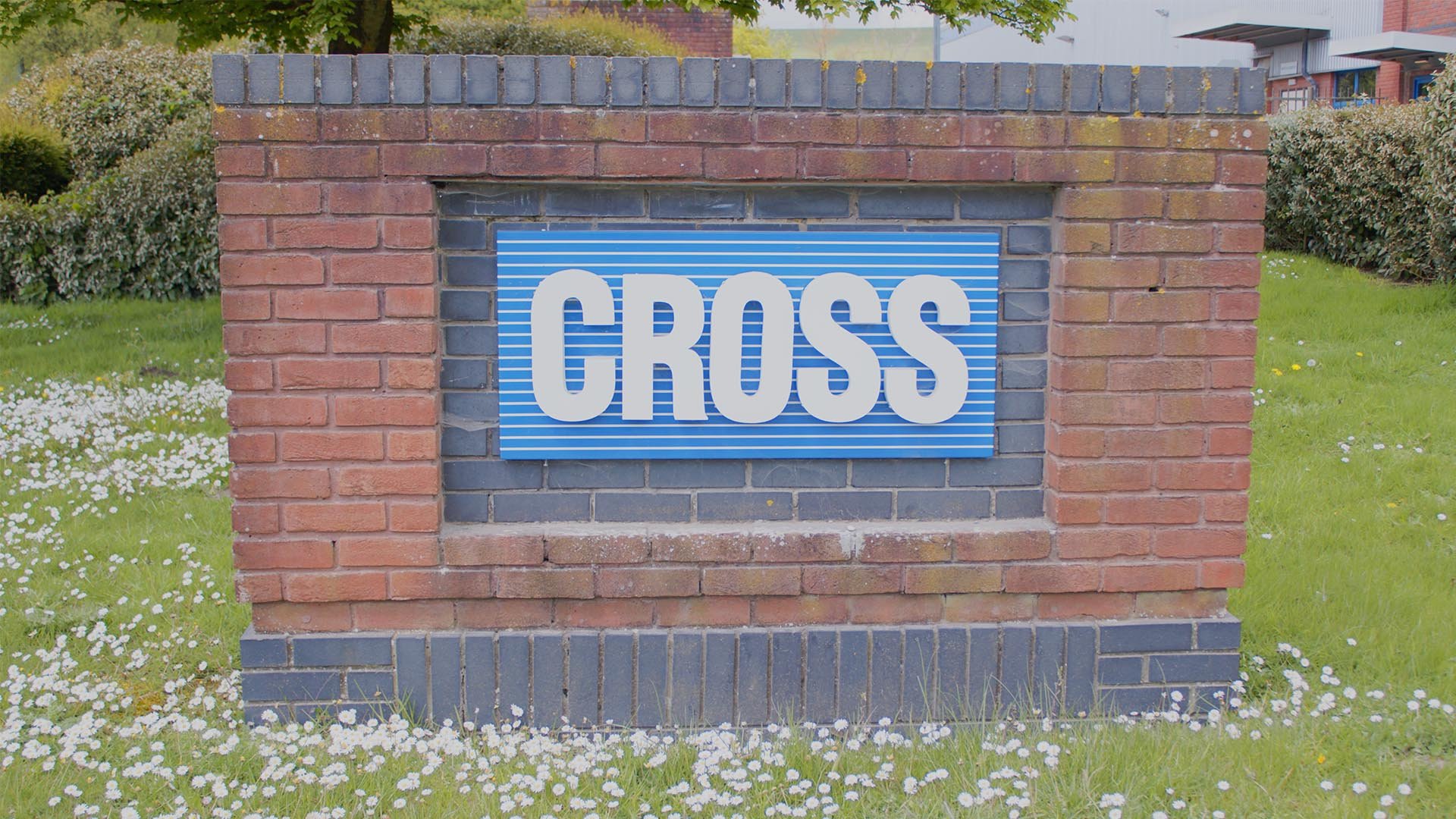 Brick sign structure with a blue panel displaying the word 
